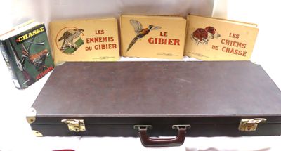 quatre livres posés sur la table, à côté d'une valise