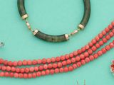 de nombreux colliers et bracelets de toutes sortes disposés sur un fond turquoise