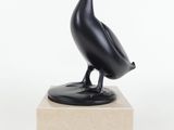 sculpture représentant un oiseau noir posée sur un socle en marbre