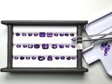 un plateau avec des pierres précieuses violettes et une paire de baguettes
