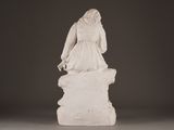 statue of a woman in a white dress standing on a rock