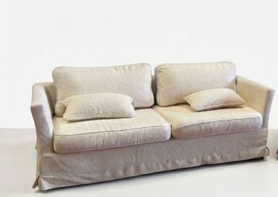 a white couch with two pillows on it in a room