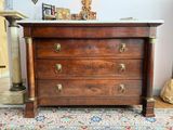 une commode en bois avec un plateau en marbre, posée sur un tapis