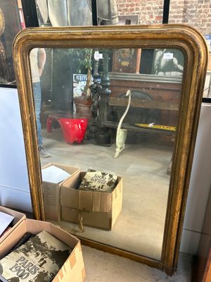 a mirror that is sitting on the floor next to a box of boxes
