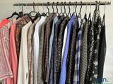 a lot of shirts hanging on a rack in a room