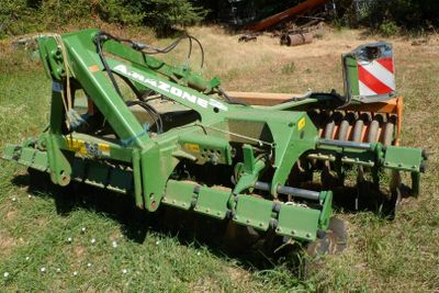 un tracteur vert qui est garé dans l'herbe
