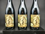 trois bouteilles de vin posées sur un bloc de bois
