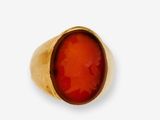 une image représentant une bague en or ornée d'une pierre de cornal au centre