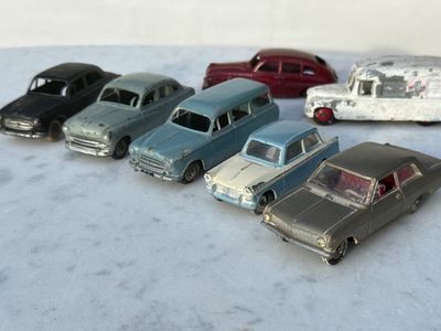 plusieurs petites voitures sont alignées sur une surface blanche
