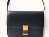 a black bag with a gold buckle on the front of it