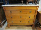 une commode en bois avec un plateau en marbre, placée dans un coin de la pièce