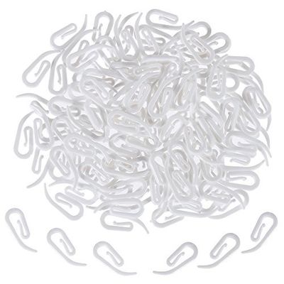 a pile of white paper clips on a white surface