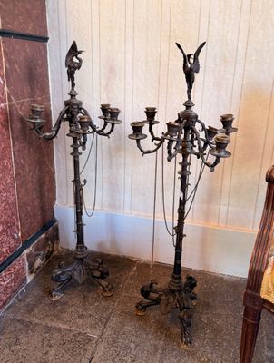 two antique candelabs sitting next to each other on the floor