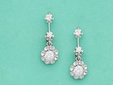 une paire de boucles d'oreilles en diamant sur fond turquoise