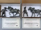 two figurines of horses and a carriage in a box