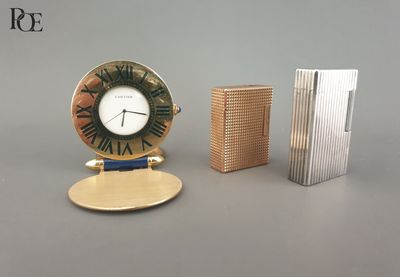 une horloge posée à côté d'un briquet et d'un livre