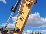 a yellow excavator that is sitting in a parking lot