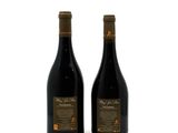 two bottles of wine sitting next to each other on a white surface