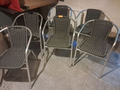 quatre chaises sont alignées en rangée sur un sol carrelé