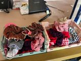two baskets filled with different types of clothes sitting on a desk