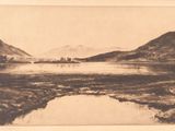 une photo en noir et blanc d'un lac avec des montagnes en arrière-plan