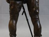 bronze statue of a man with a hat and a cane
