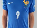 Cet homme porte une chemise bleue sur laquelle est représenté un coq.