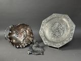 une assiette en argent posée à côté d'une assiette en argent sur laquelle est représenté un oiseau