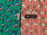 three different colored ties with different designs on them on a table