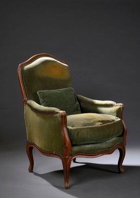 une vieille chaise avec un coussin rembourré vert et une structure en bois