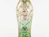 a glass vase that has a gold and green design on it