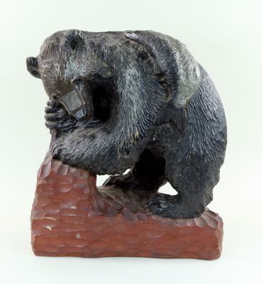 une statue représentant un ours assis sur un rocher