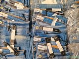 several pairs of blue jeans are packed in plastic bags on a table