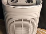 a white air purifier sitting on a wooden table