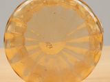 a yellow glass vase sitting on a wooden table