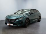 La voiture verte est garée dans une grande pièce au sol noir.