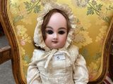 a doll that is sitting on a chair in a room