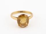 un gros plan d'une bague en or jaune sertie d'une citrine de taille ovale