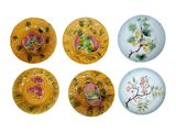 four plates with flowers and leaves painted on them on a white surface
