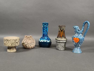 five different colored vases sitting next to each other on a table