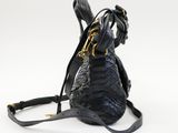 the black snake skin bag is on a white surface