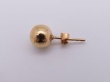 a close up of a pair of gold earrings on a white surface