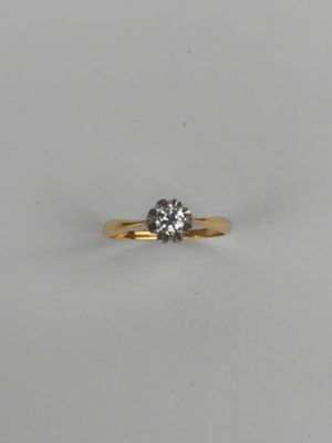 a single stone diamond ring on a white surface
