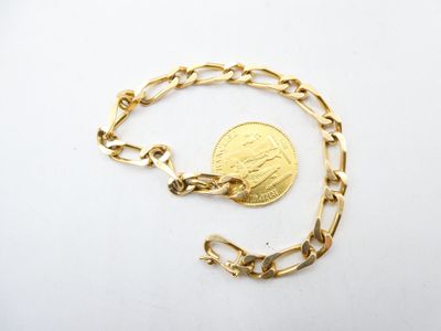 a close up of a gold chain with a coin on it