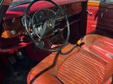 une voiture rouge avec des sièges en cuir et un volant