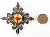 a small piece of metal with a red flower on it next to a penny