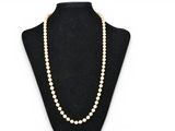 a white pearl necklace on a black mannequin