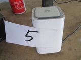 un réfrigérateur blanc sur lequel figure un numéro, à côté d'une canette de soda