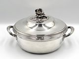 a silver plated casserole with a flower on top