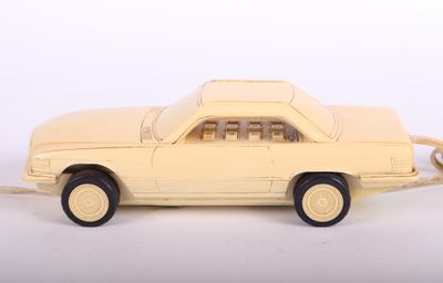 petite voiture jaune posée sur une surface blanche, sur fond blanc
